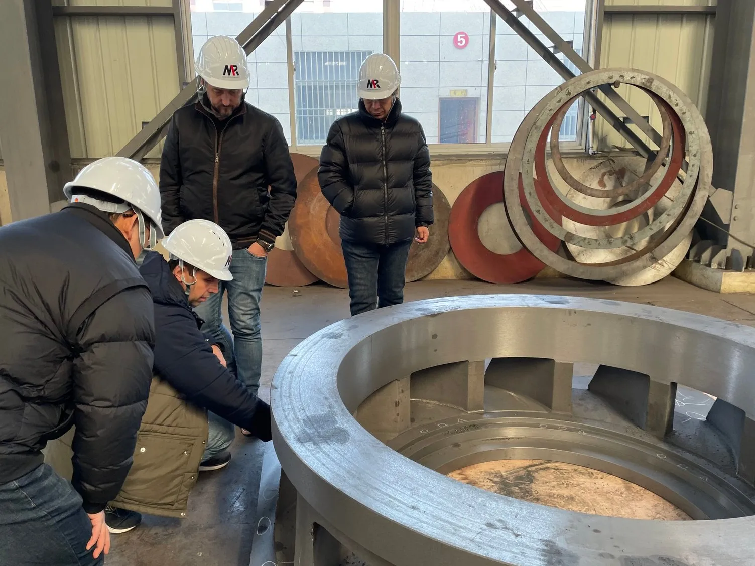 Técnicos inspecionando peças fundidas de grande porte